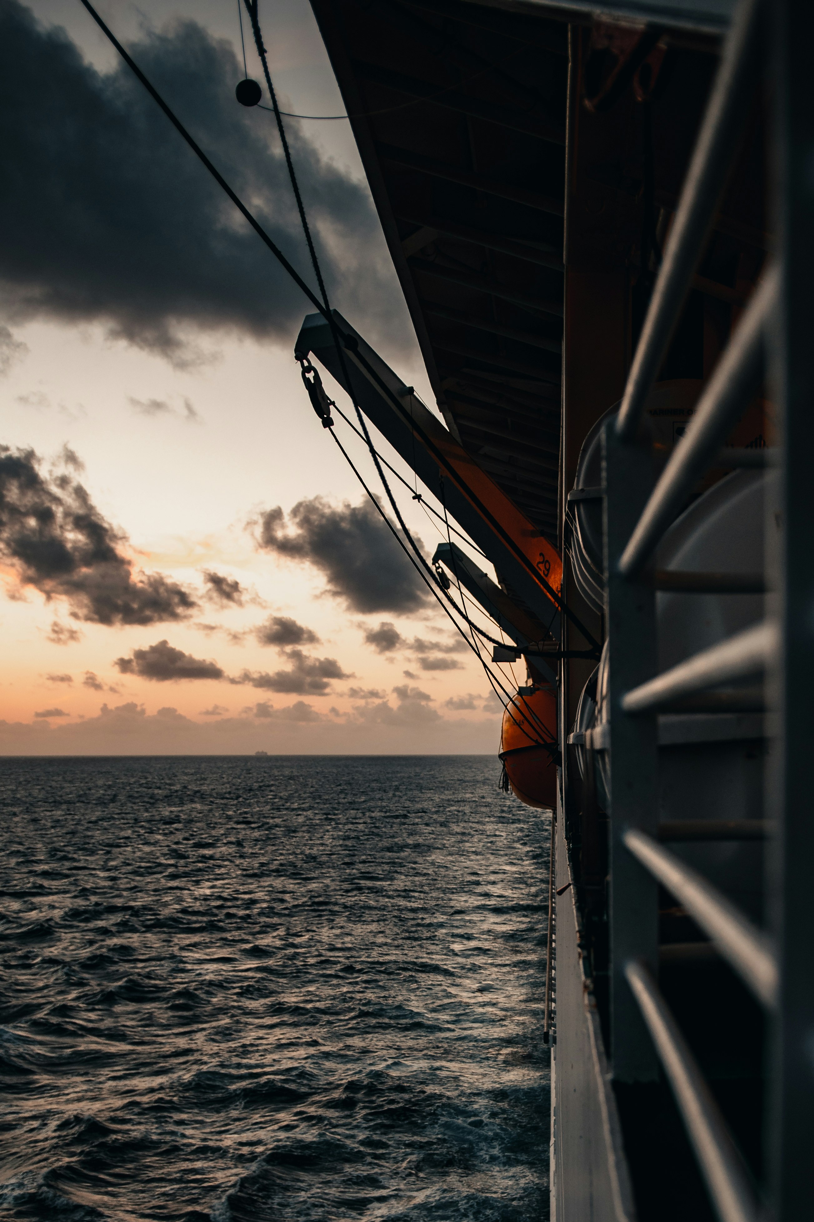 black ship on sea during sunset